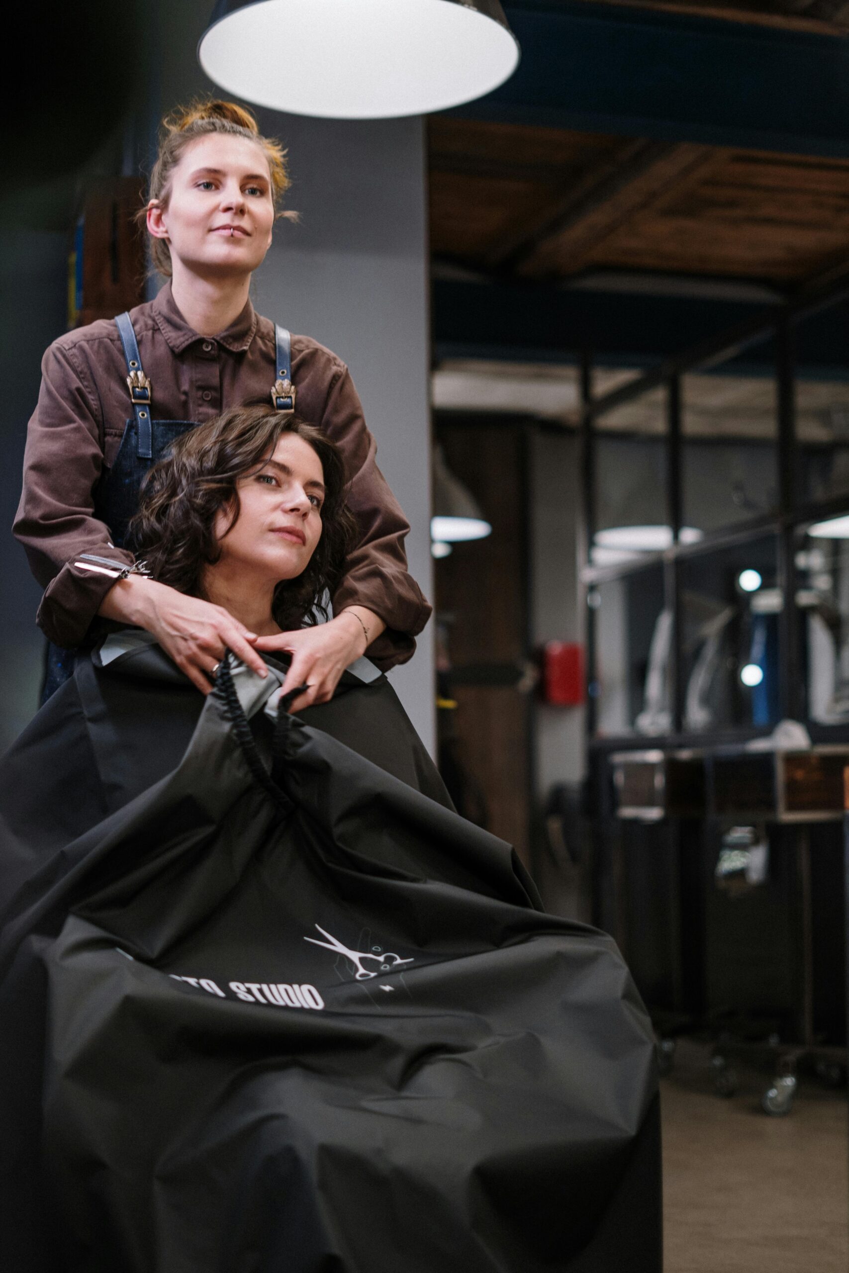 A stylist prepares a client's hair in a modern salon setting, showcasing the art of professional hairstyling.